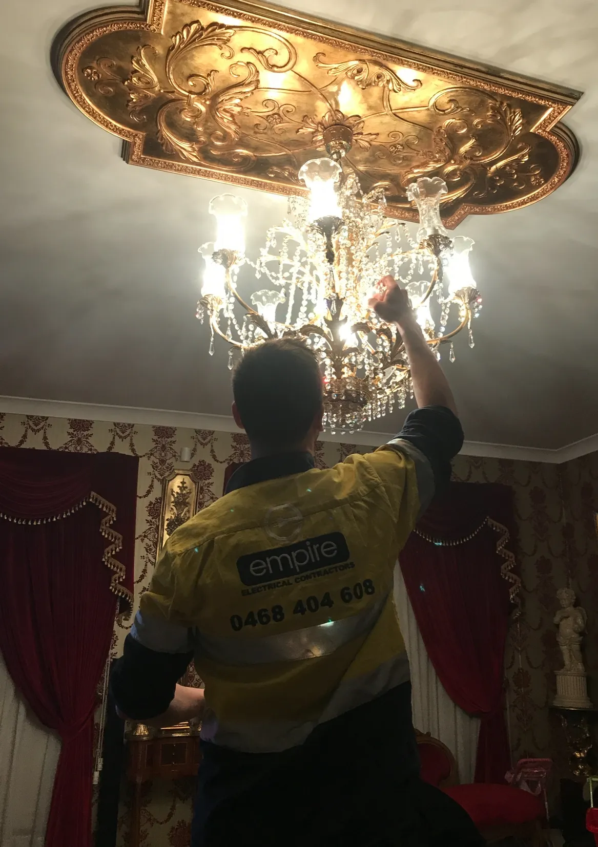 Empire electrician installing a chandelier in a Sydney home